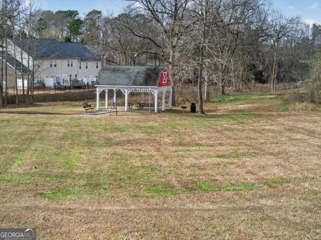 a front view of residential houses with yard and trees