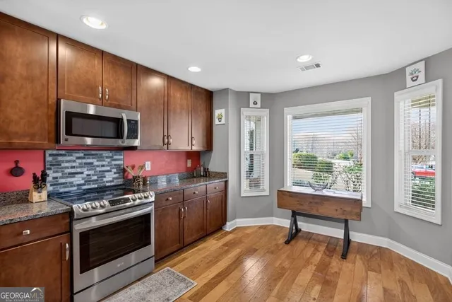 a bathroom with a granite countertop toilet a sink a mirror and a shower curtain