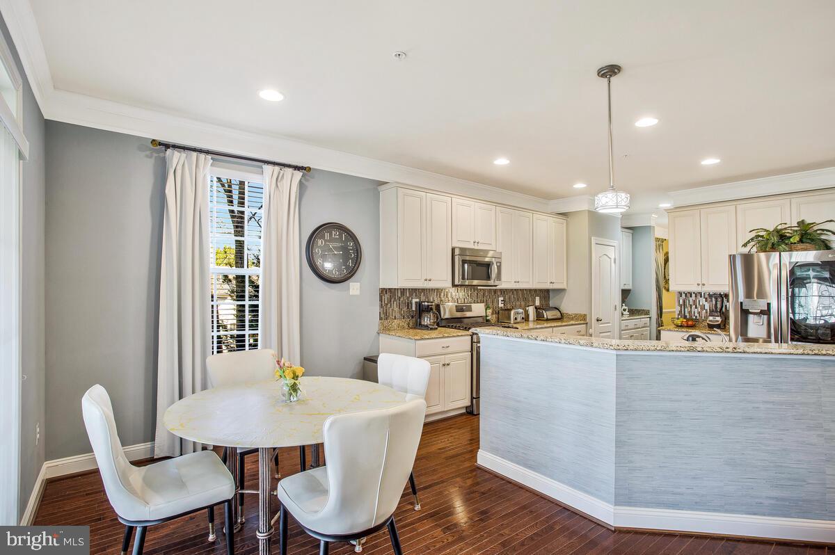 802 Phyllis Street Odenton, MD 21113 - Photo 11 of 35 a dining room with kitchen island stainless steel appliances furniture a dining table and chairs