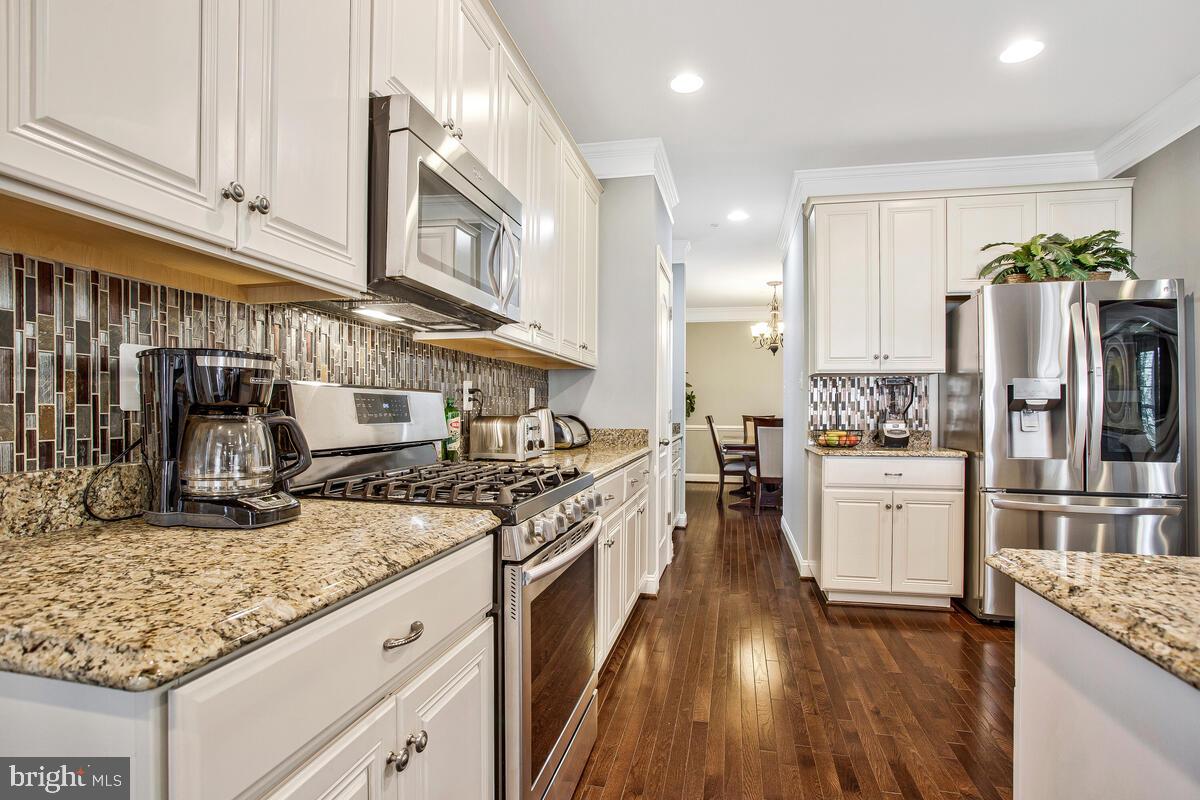 802 Phyllis Street Odenton, MD 21113 - Photo 8 of 35 a kitchen with granite countertop kitchen island stainless steel appliances a refrigerator a stove top oven and sink