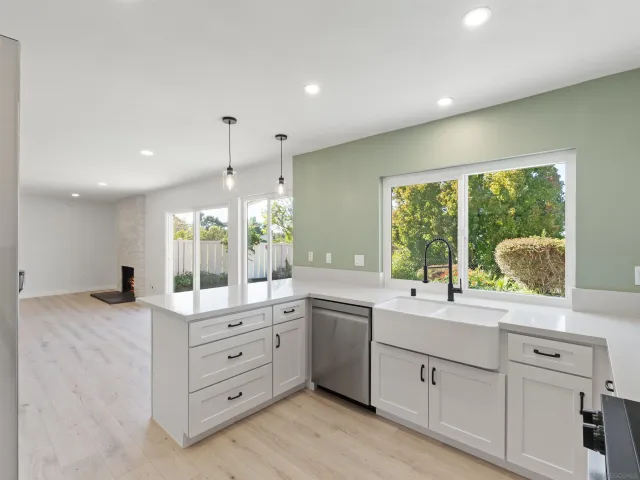 a large white kitchen with a large window
