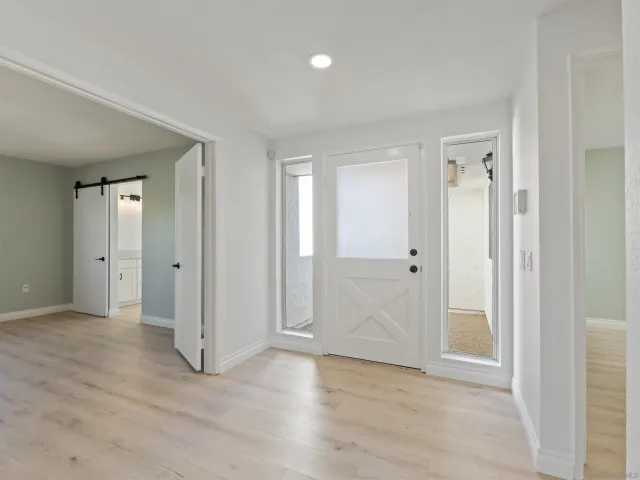 a view of an empty room with closet and a window