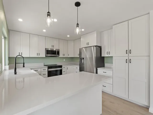 a kitchen with stainless steel appliances granite countertop a refrigerator a sink and a stove