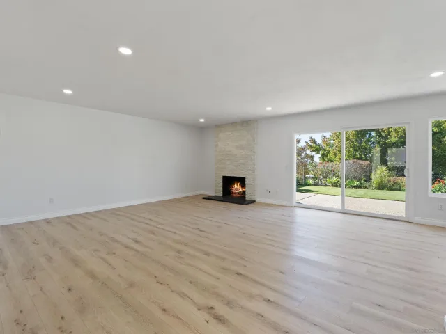 a view of empty room with wooden floor and fireplace