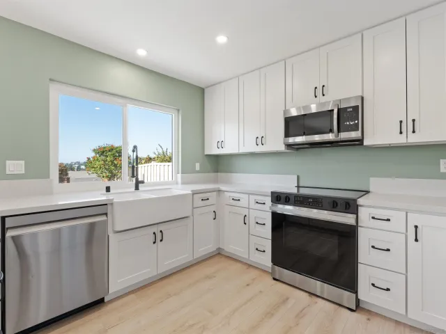 a kitchen with white cabinets and white appliances