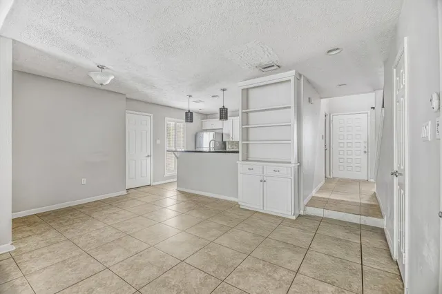 a view of a kitchen with white cabinets and refrigerator