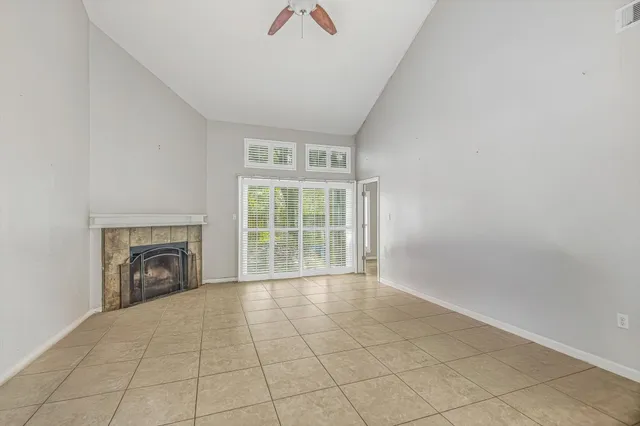 a view of an empty room with a fireplace and a window