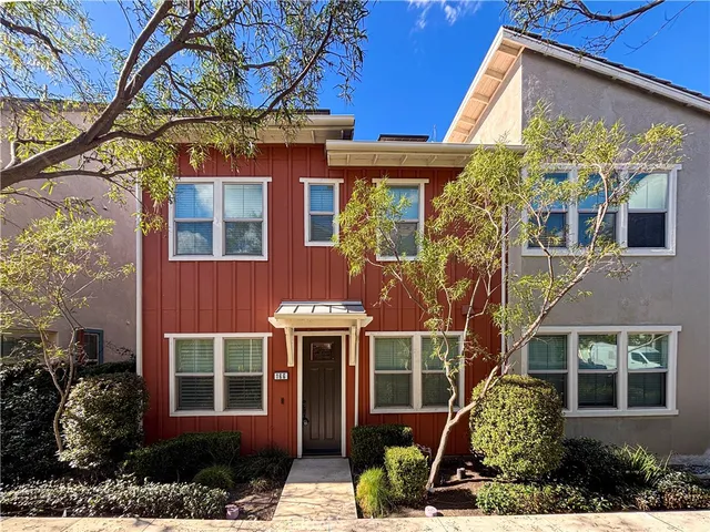 a view of a brick house with large windows and a tree