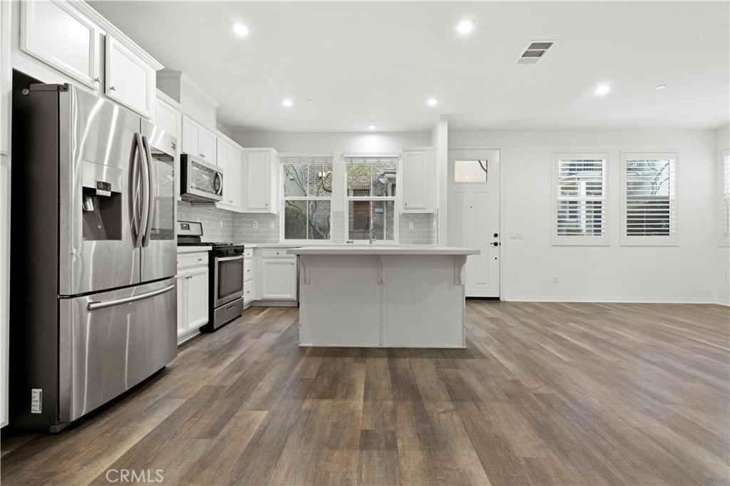 166 Natal Road Rancho Mission Viejo, CA 92694 - Photo 30 of 45 a kitchen with stainless steel appliances granite countertop a refrigerator a stove a sink dishwasher and a oven with wooden floor