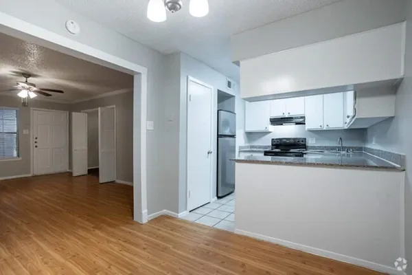a view of a kitchen with stainless steel appliances granite countertop a refrigerator and a stove top oven