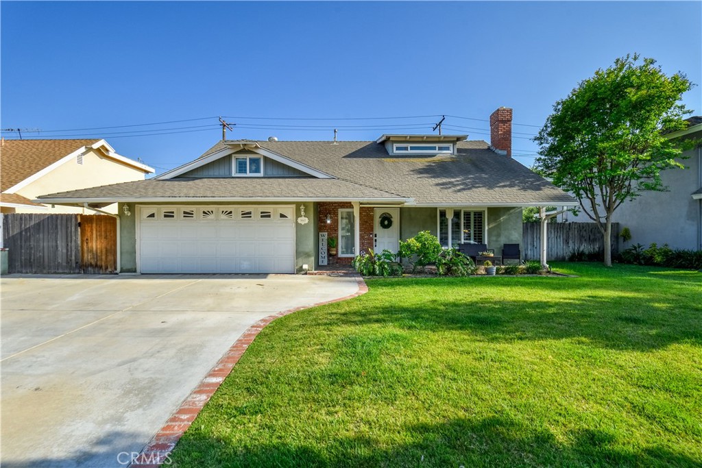 a front view of a house with a yard and trees