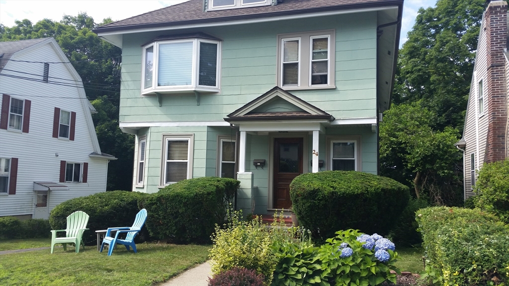 a front view of a house with garden and porch
