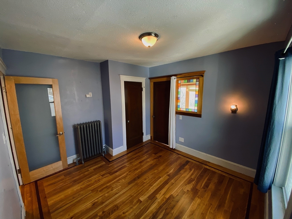 2-4 Sunset Hill Road Boston, MA 02132 - Photo 20 of 34 a view of an empty room with wooden floor and a window