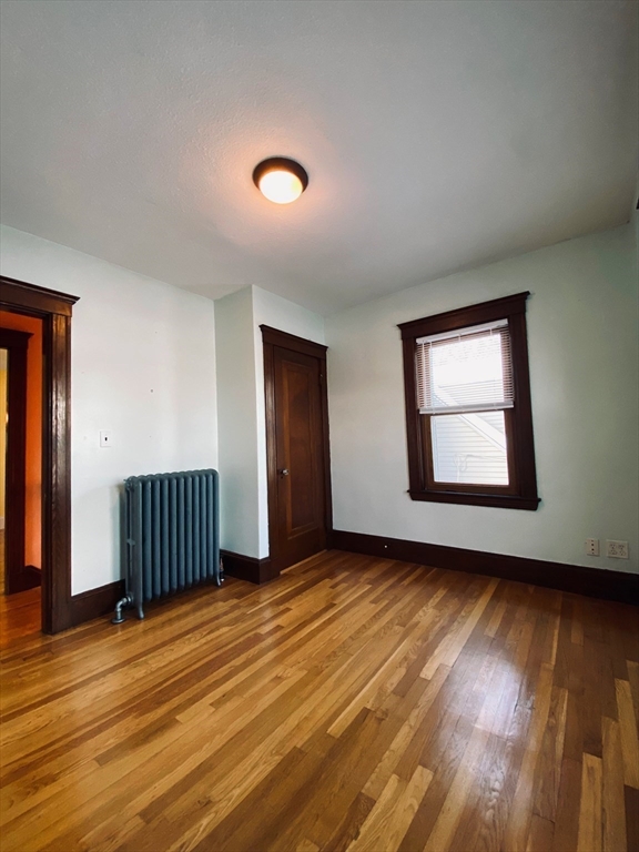 2-4 Sunset Hill Road Boston, MA 02132 - Photo 28 of 34 an empty room with wooden floor and windows