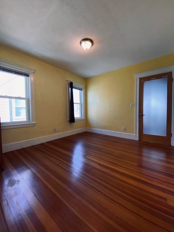 2-4 Sunset Hill Road Boston, MA 02132 - Photo 29 of 34 a view of an empty room with wooden floor and a window