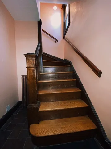 a view of a hallway with wooden floor and closet