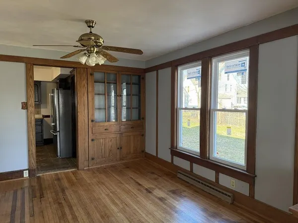 a view of an empty room with window and wooden floor