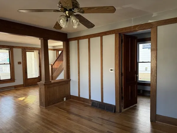 a view of a hallway with wooden floor and chandelier