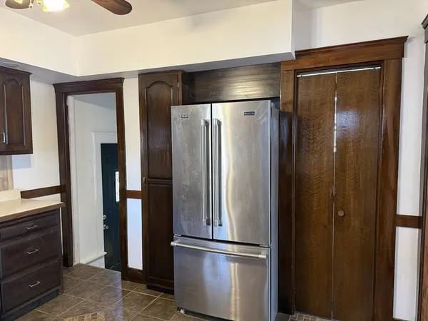 a metallic refrigerator freezer sitting in a kitchen