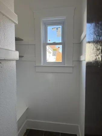a small space with wooden floor and windows