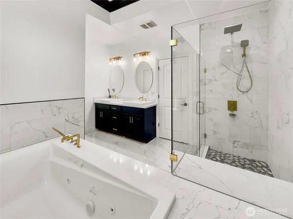 a bathroom with a tub sink shower and mirror