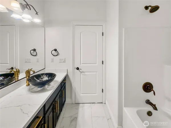 a bathroom with a tub sink and mirror
