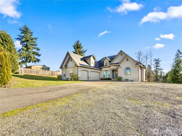 a view of big yard in front of house with large tree