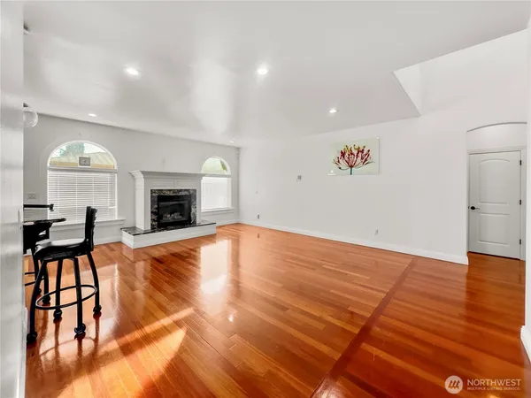 an empty room with wooden floor and fireplace