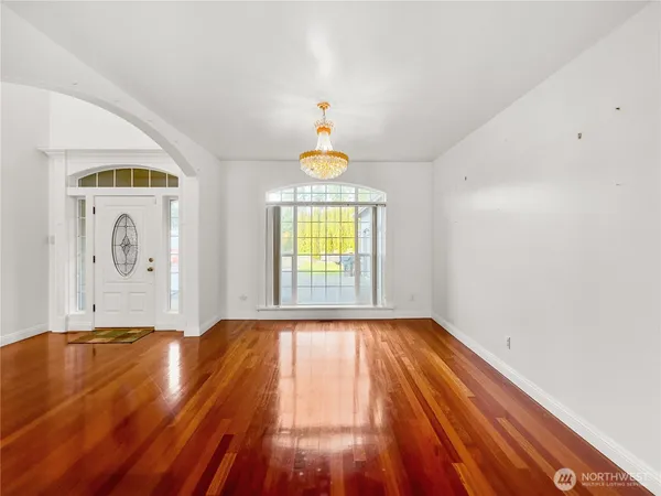 a view of empty room with window and wooden floor