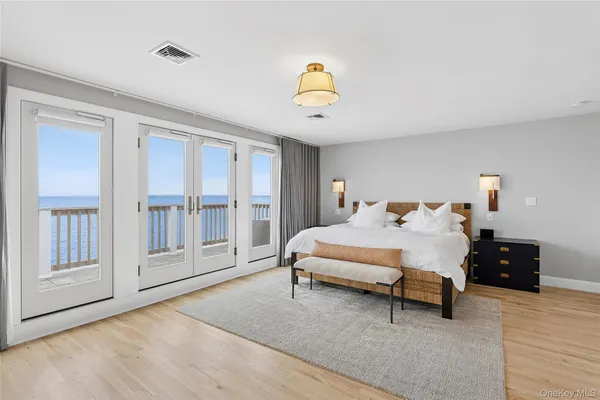 a spacious bedroom with a bed a table and windows