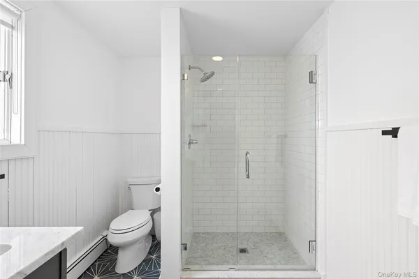 a bathroom with a shower a toilet and a window