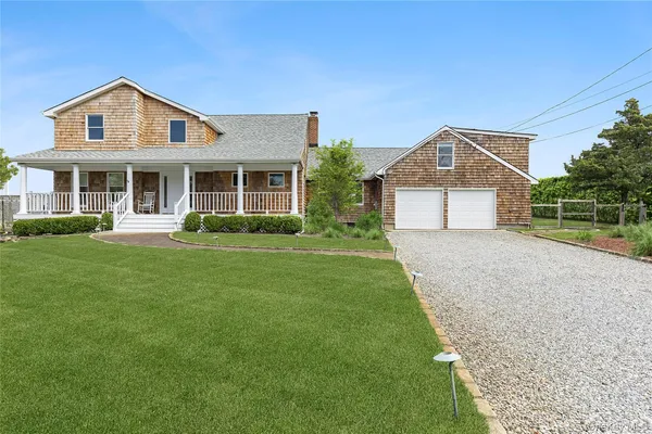a front view of a house with a yard and trees