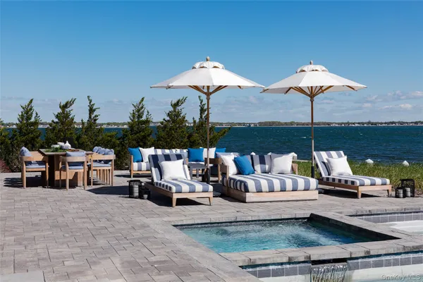 a roof deck with table and chairs under an umbrella