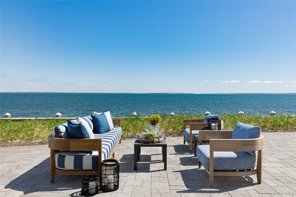 an outdoor living room with furniture and a floor to ceiling window