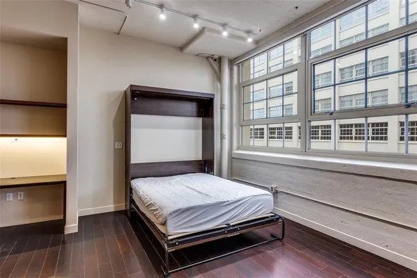 a bedroom with a bed and a large window