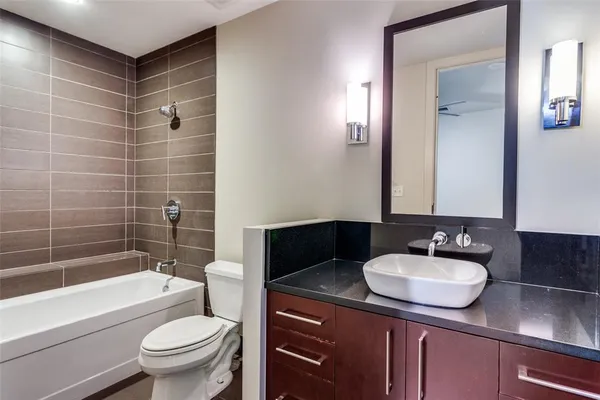 a bathroom with a sink toilet a mirror and bathtub