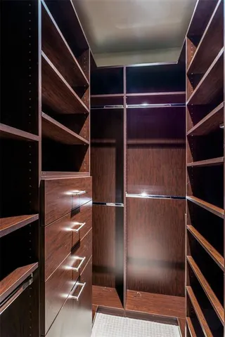 a view of walk in closet with empty racks