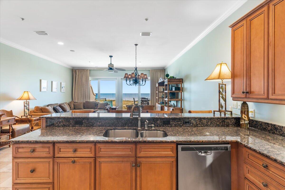 7923 Gulf Boulevard Navarre, FL 32566 - Photo 11 of 33 a kitchen with kitchen island granite countertop a sink a counter space appliances and cabinets
