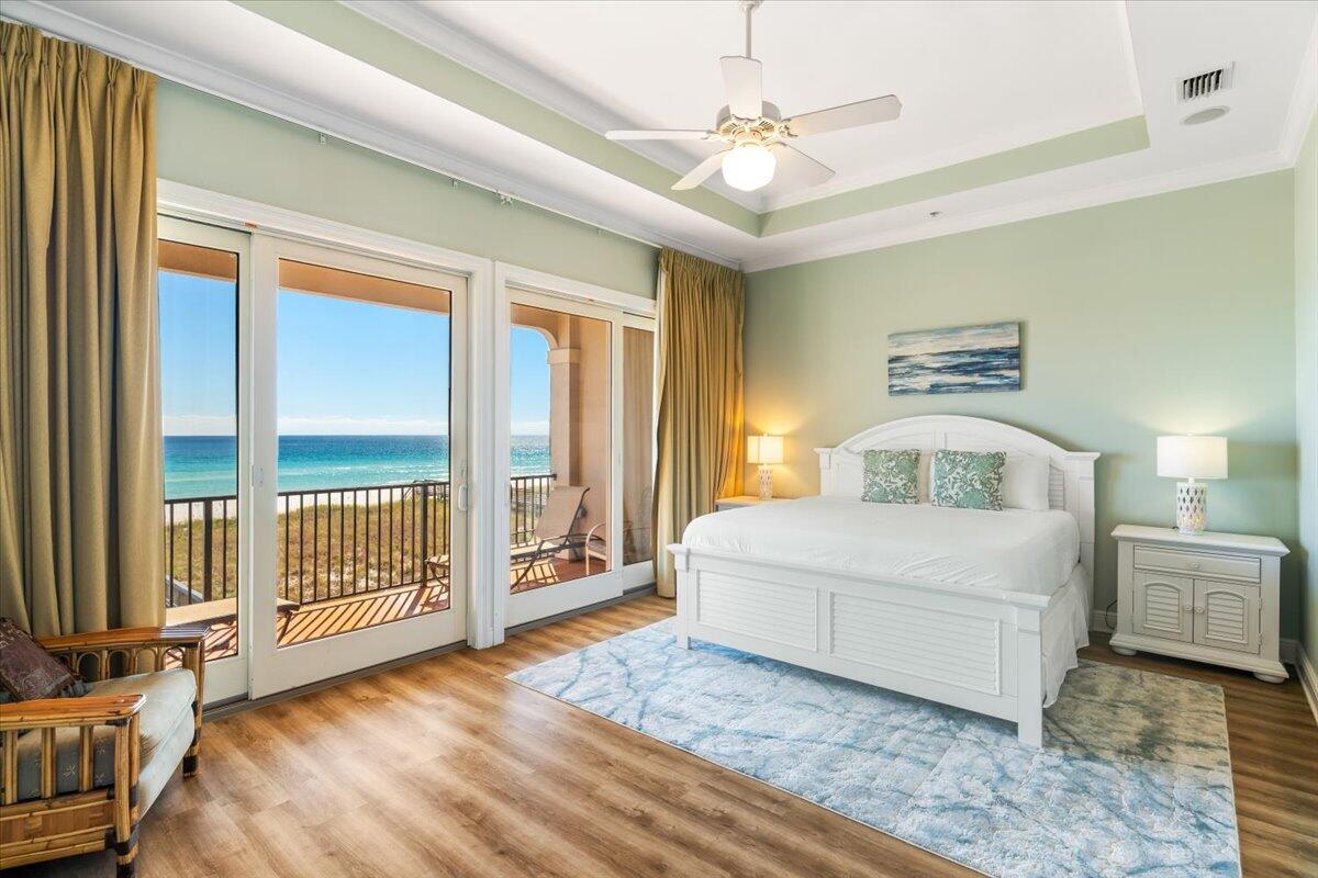 7923 Gulf Boulevard Navarre, FL 32566 - Photo 6 of 33 a bedroom with a large bed and a chandelier