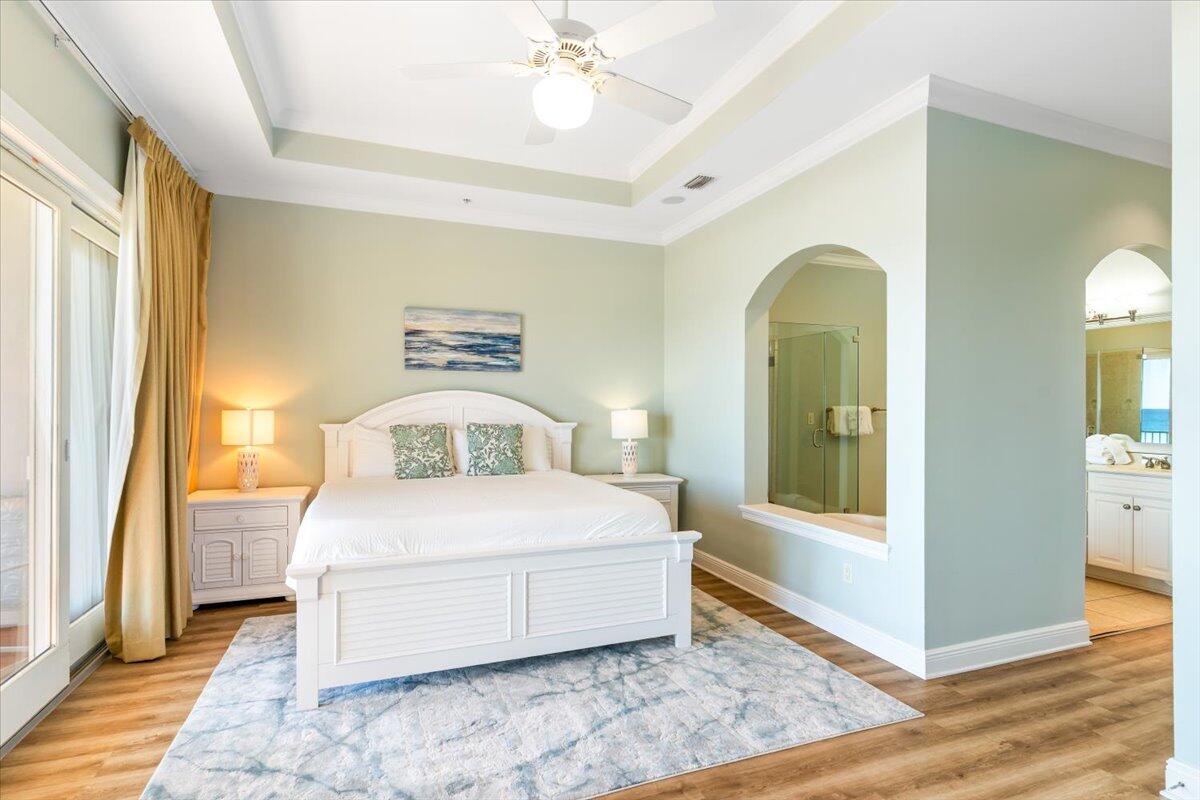 7923 Gulf Boulevard Navarre, FL 32566 - Photo 7 of 33 a bedroom with a large bed and a chandelier