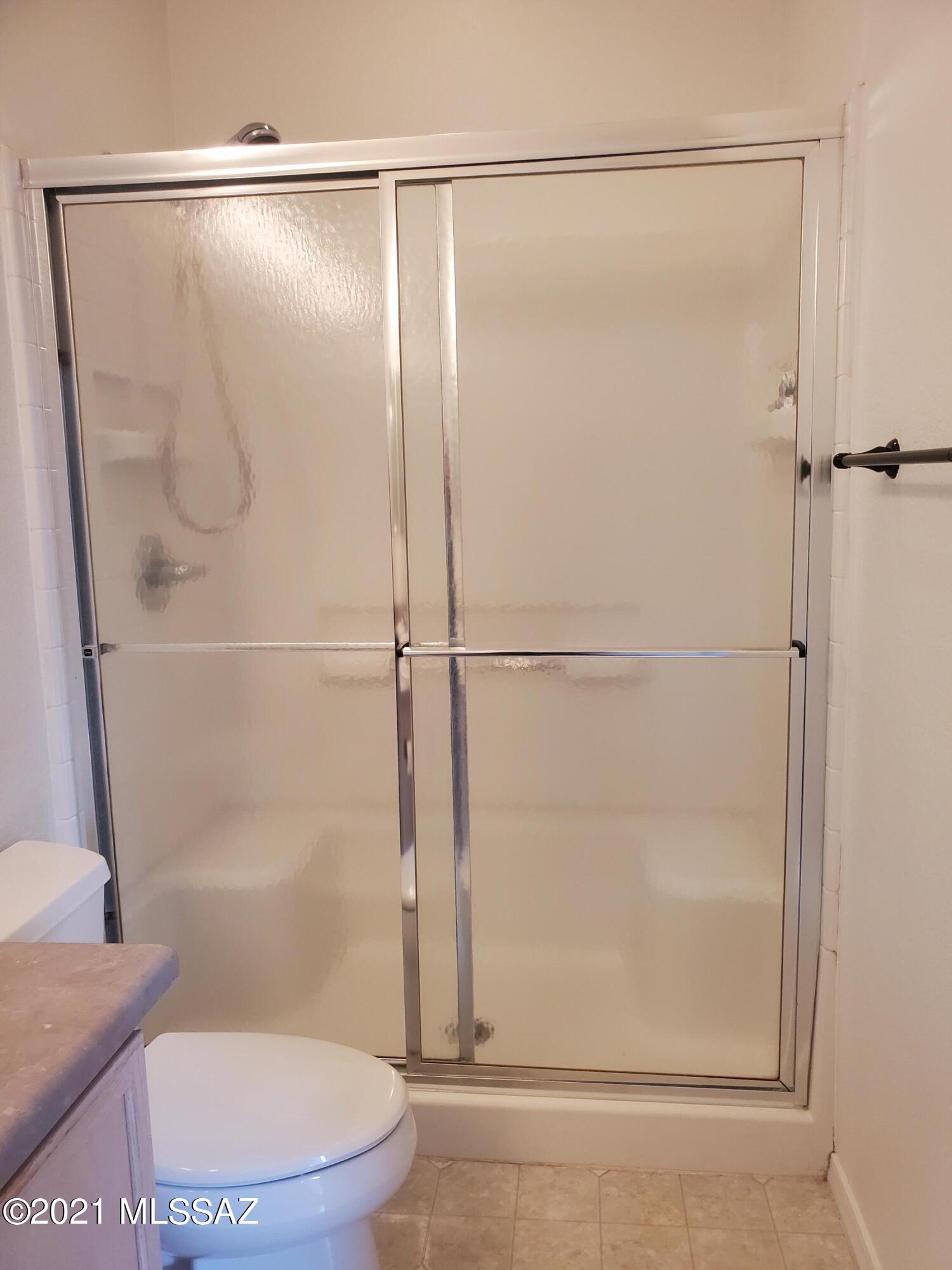 3455 North Boyce Spring Lane Tucson, AZ 85745 - Photo 18 of 21 a bathroom with a glass shower door