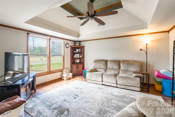 a living room with furniture a flat screen tv and a large window