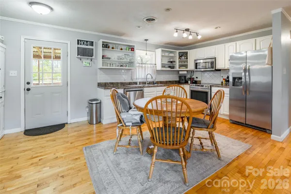 a dining room dining table chairs and a refrigerator