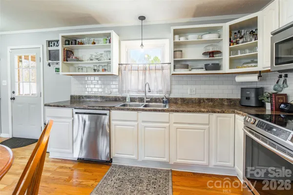 a kitchen with stainless steel appliances granite countertop a stove a sink and a microwave