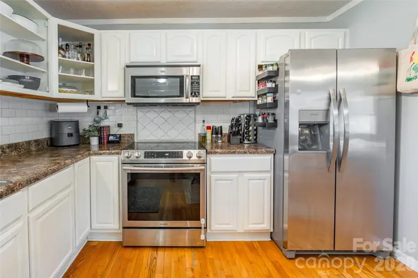 a kitchen with stainless steel appliances granite countertop a refrigerator and a stove top oven