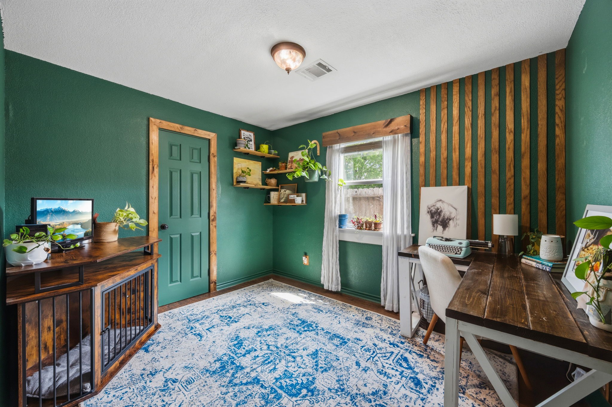 431 Corydon Drive Houston, TX 77336 - Photo 14 of 26 Cozy secondary bedroom currently used as a home office featuring rich green walls, wood accents, and a large window that fills the space with natural light.