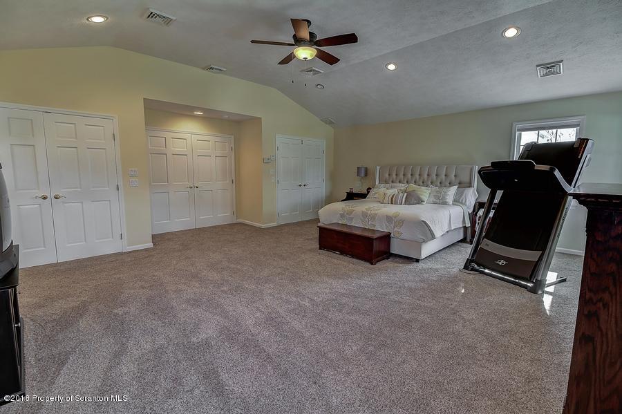 360 Upper Demunds Road Dallas, PA 18612 - Photo 27 of 40 a spacious bedroom with a bed and gym equipment