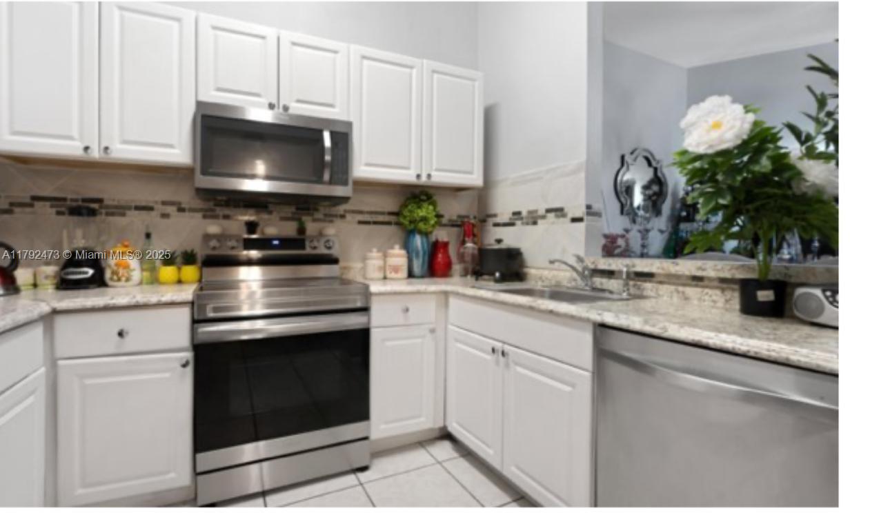 a kitchen with stainless steel appliances granite countertop a sink a stove and a microwave