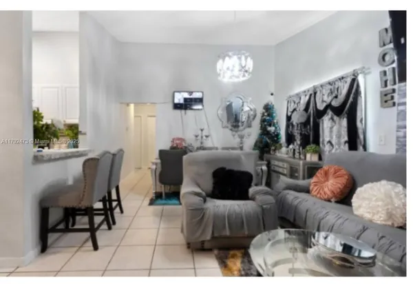 a living room with furniture a flat screen tv and a dining table