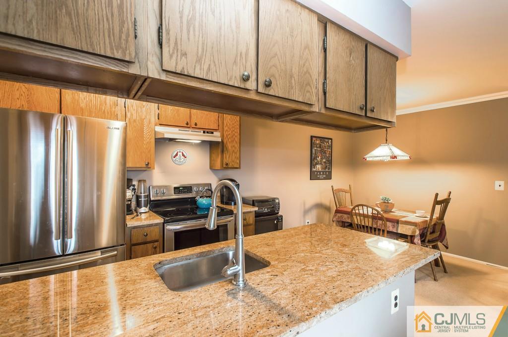 52 Bolton Court Somerset, NJ 08873 - Photo 4 of 18 a kitchen with stainless steel appliances granite countertop a sink stove and cabinets